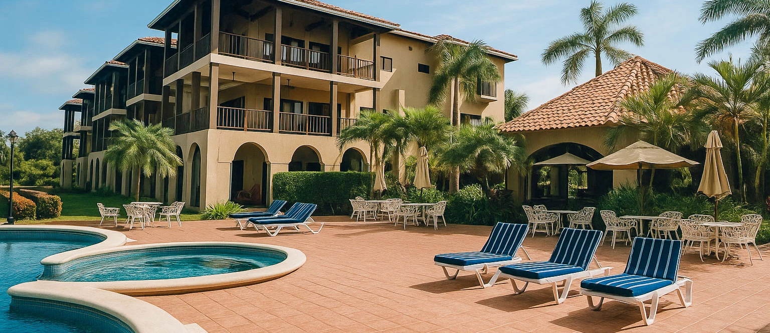 A sunny resort scene with a curved pool, lounge chairs, umbrellas, and a multi-story hotel surrounded by palm trees.