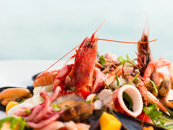 A platter of fresh seafood&mdash;prawns, mussels, clams&mdash;tossed with herbs and lemon on a bed of vegetables.